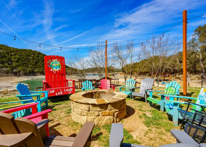 Fire pit area with colorful chairs at Camp Sandy