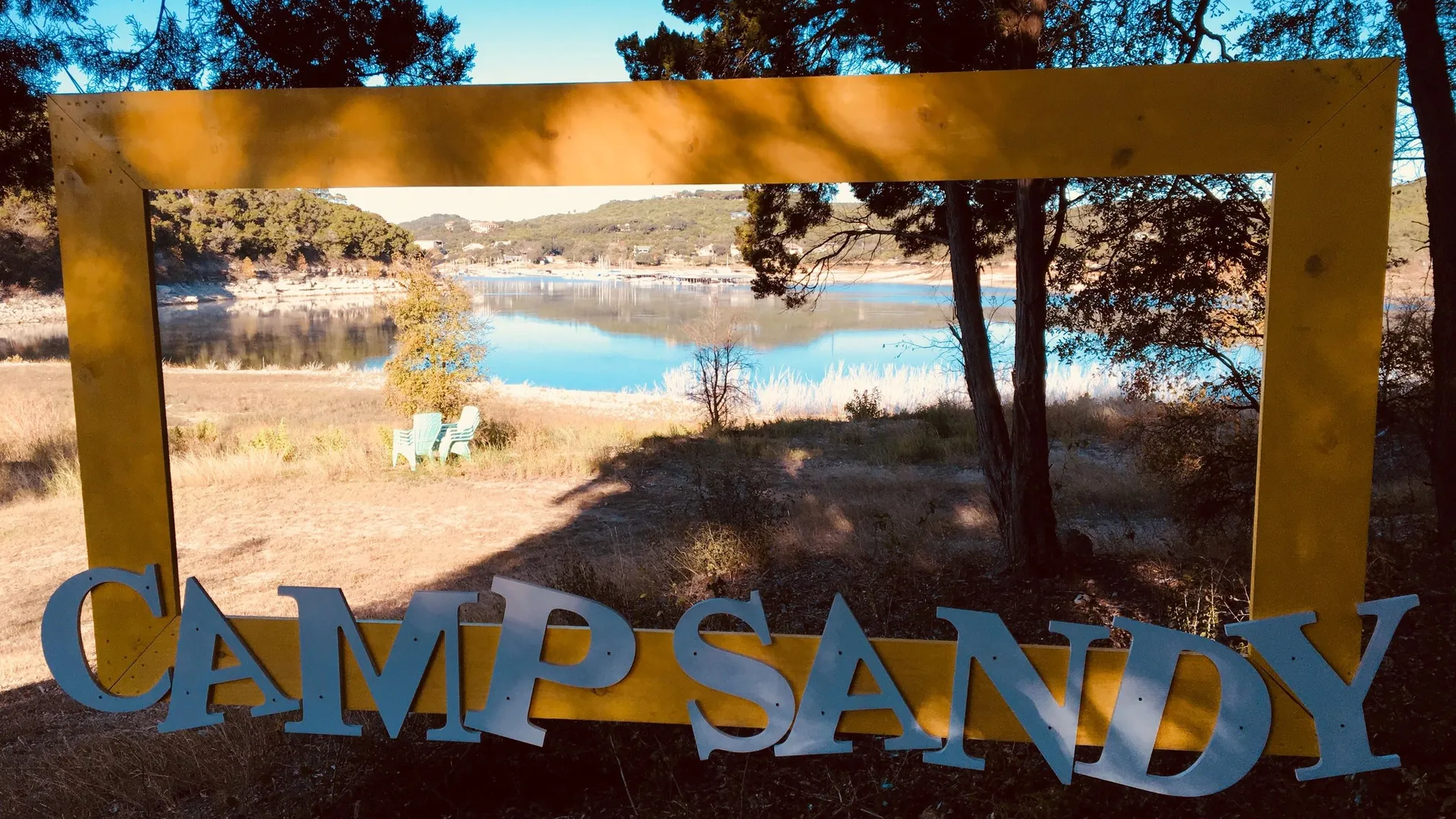 Camp Sandy sign with Lake Travis in the background